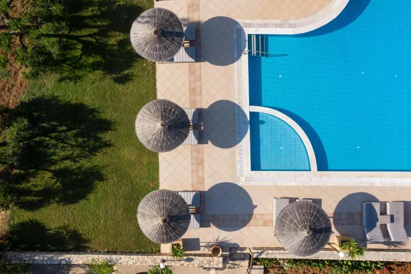 Aerial view of pool with umbrellas and lawn