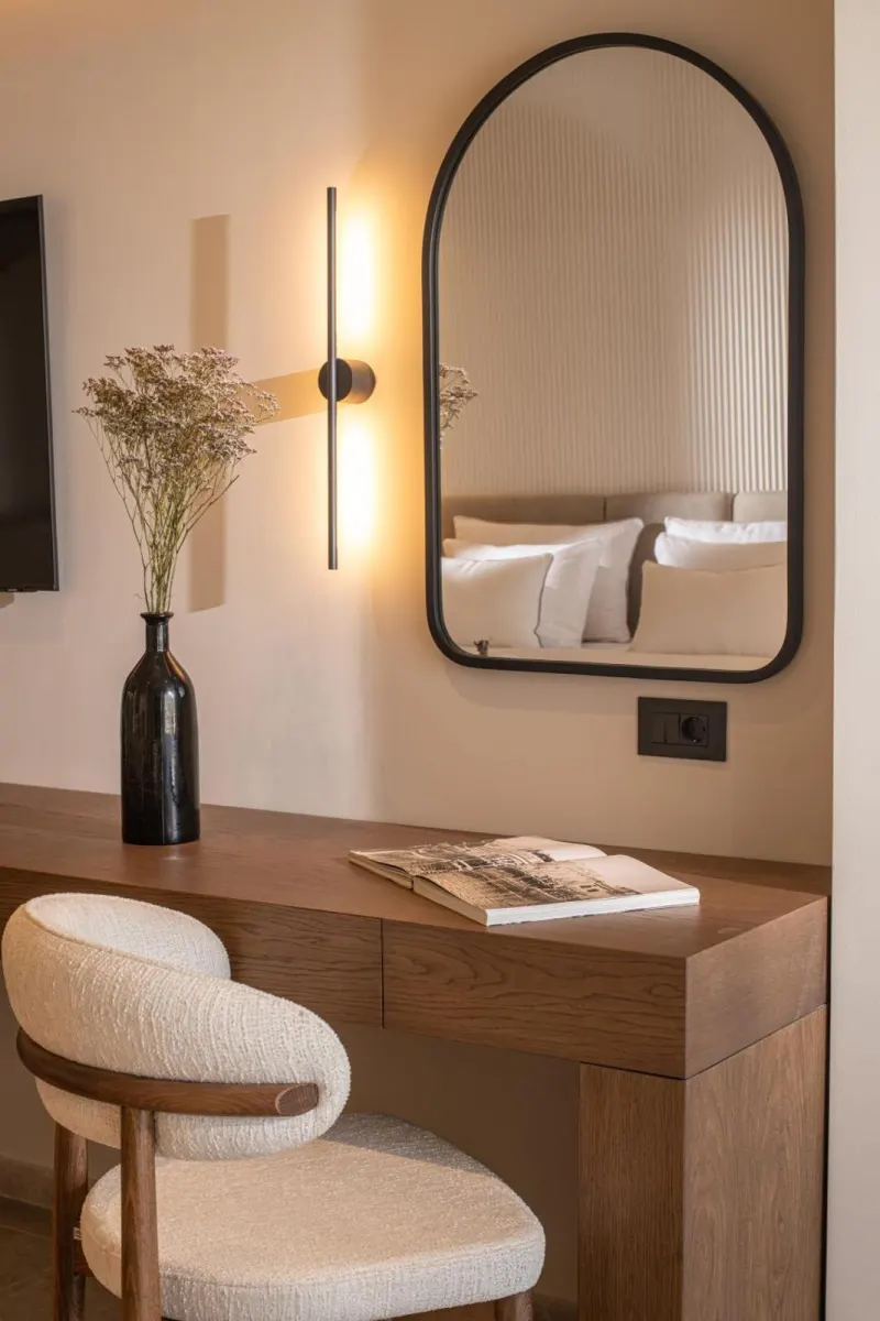 Vanity desk with arched mirror and wall sconce