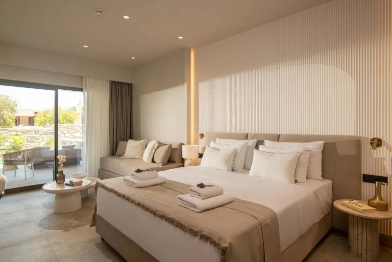 Bright bedroom with terrace view and seating area