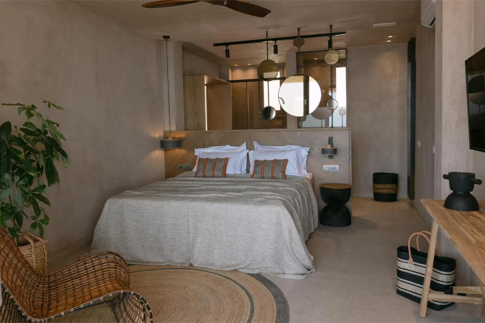 Bedroom with rattan chair and round mirrors