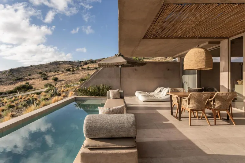Poolside terrace with dining area overlooking hillside