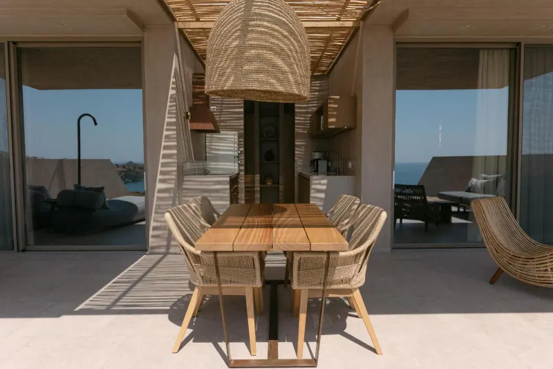 Outdoor dining table under woven pendant lamp