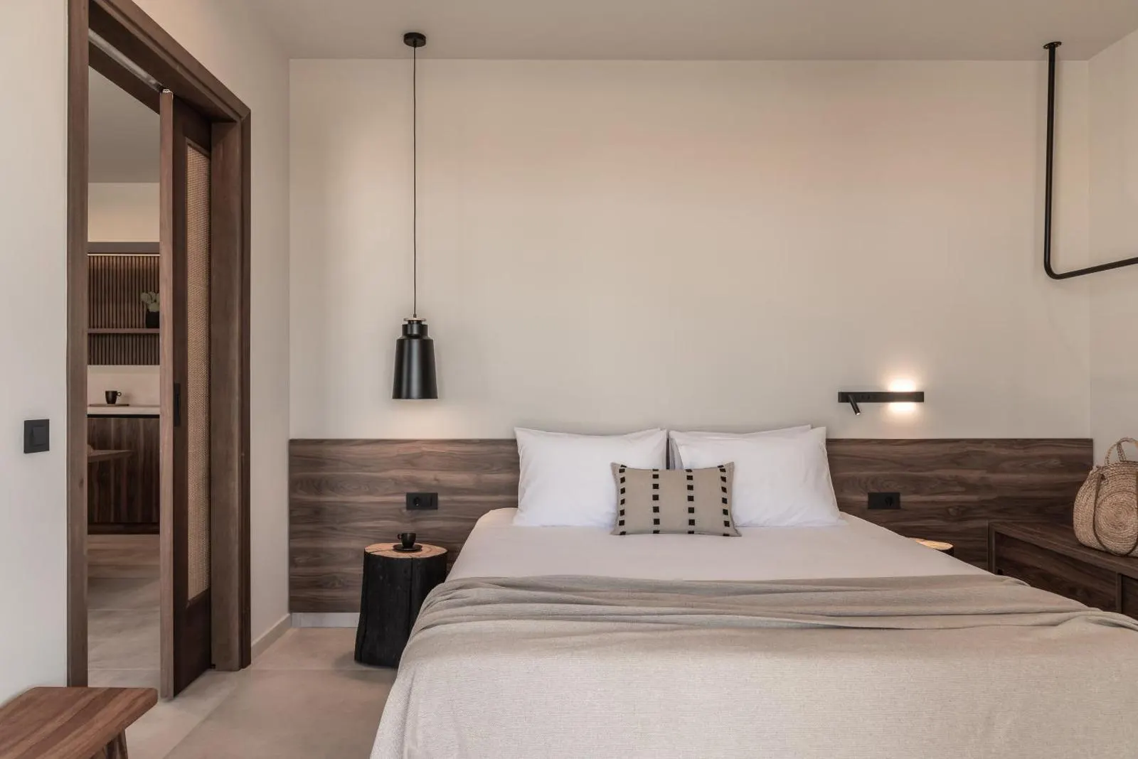 Minimalist bedroom with wood headboard and pendant light