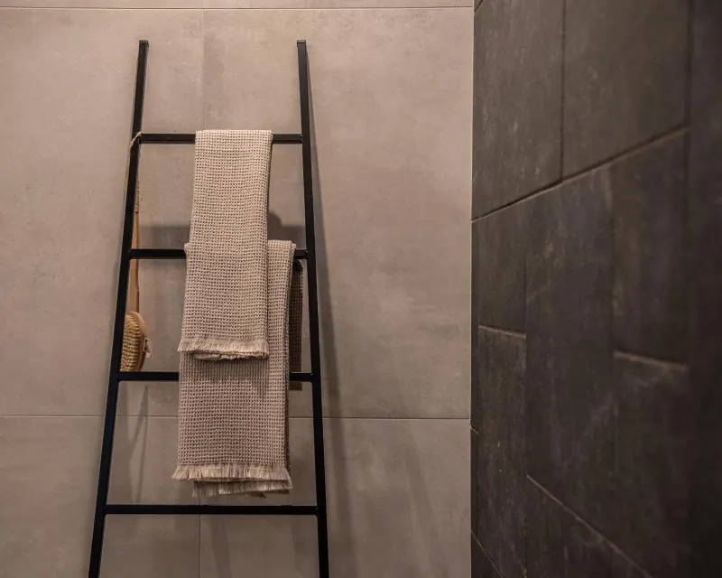 Towel ladder against textured tiled wall