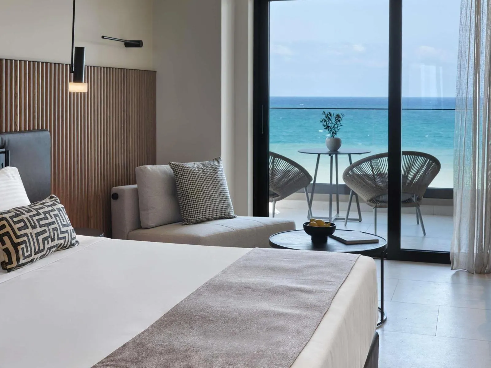 Bedroom with sea view through glass balcony doors