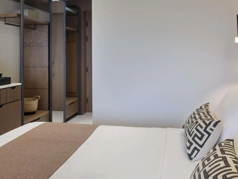Bedroom with open wardrobe and neutral tones