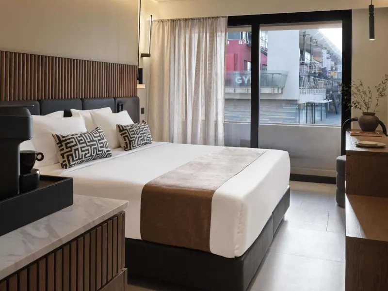 Bedroom with wood slat headboard and city view