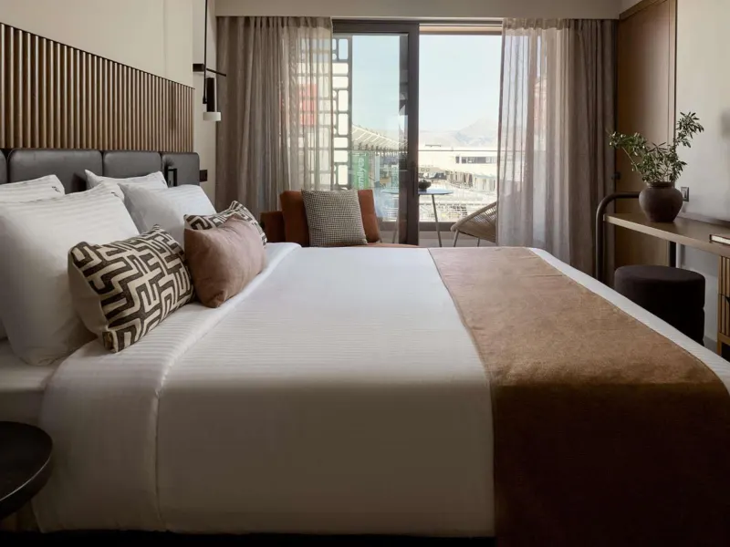Modern bedroom with striped headboard and balcony view