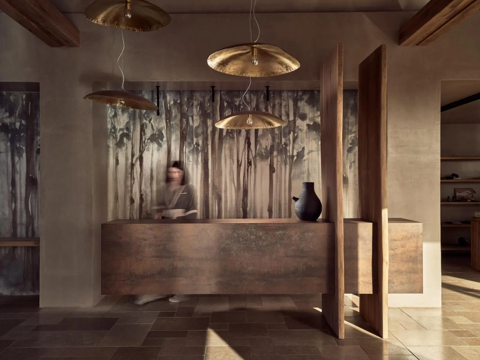 Reception desk with woodland mural and brass pendant lights