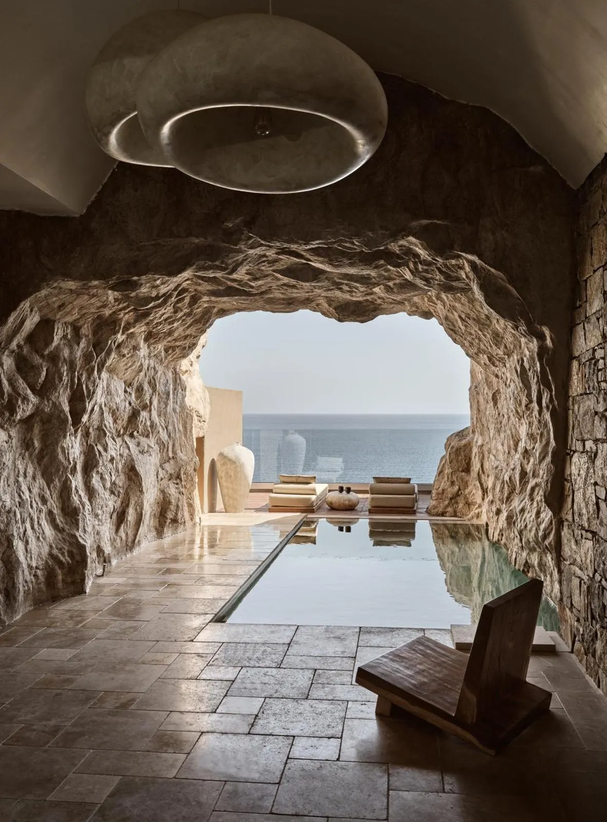 Cave-like tunnel leading to infinity pool overlooking the sea