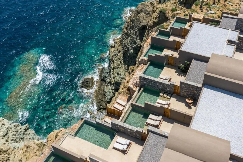 Aerial view of cliffside suites with plunge pools by the sea