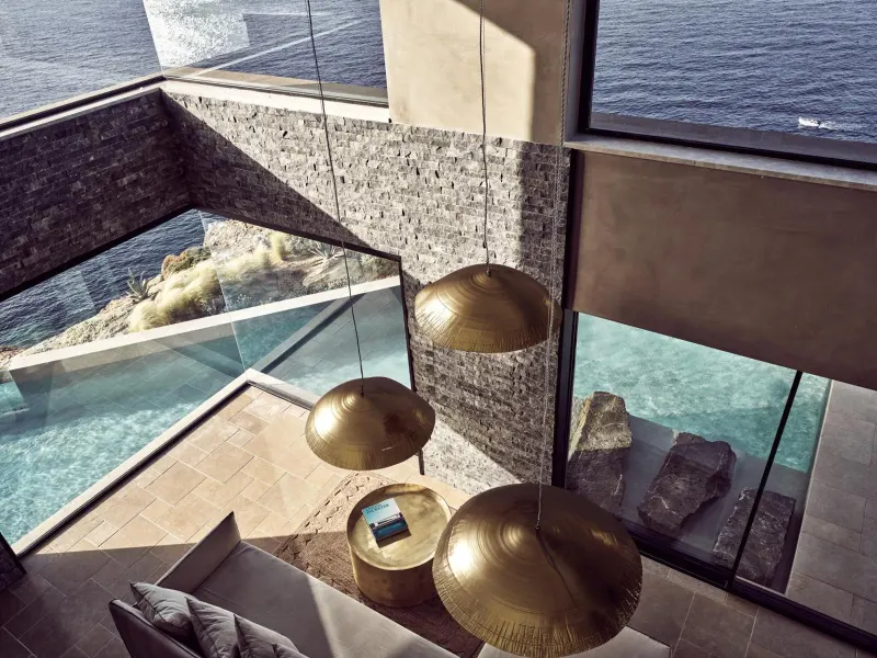 Glass balcony with brass pendant lamps over the sea