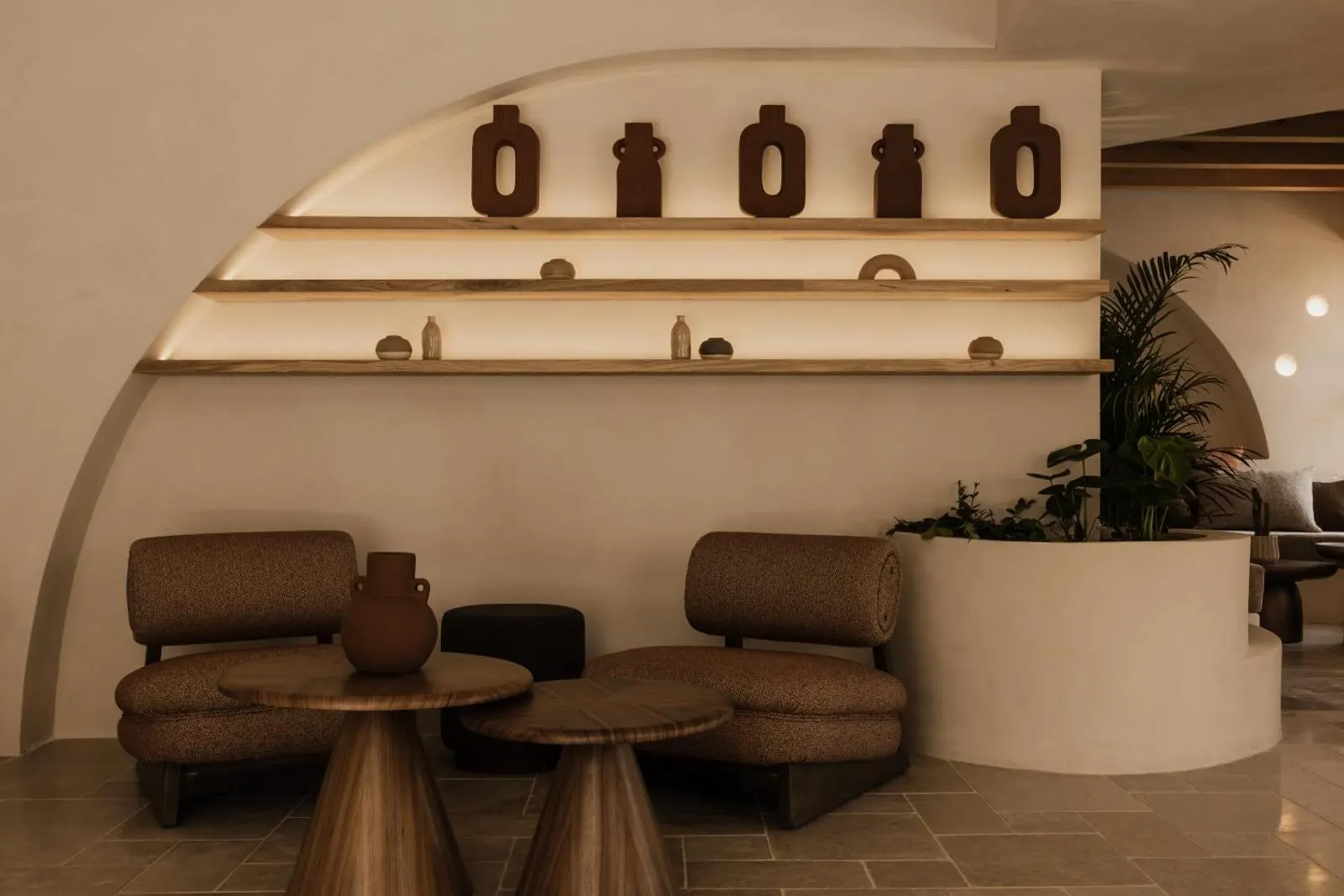 Lounge nook with ceramic vases on lit shelves