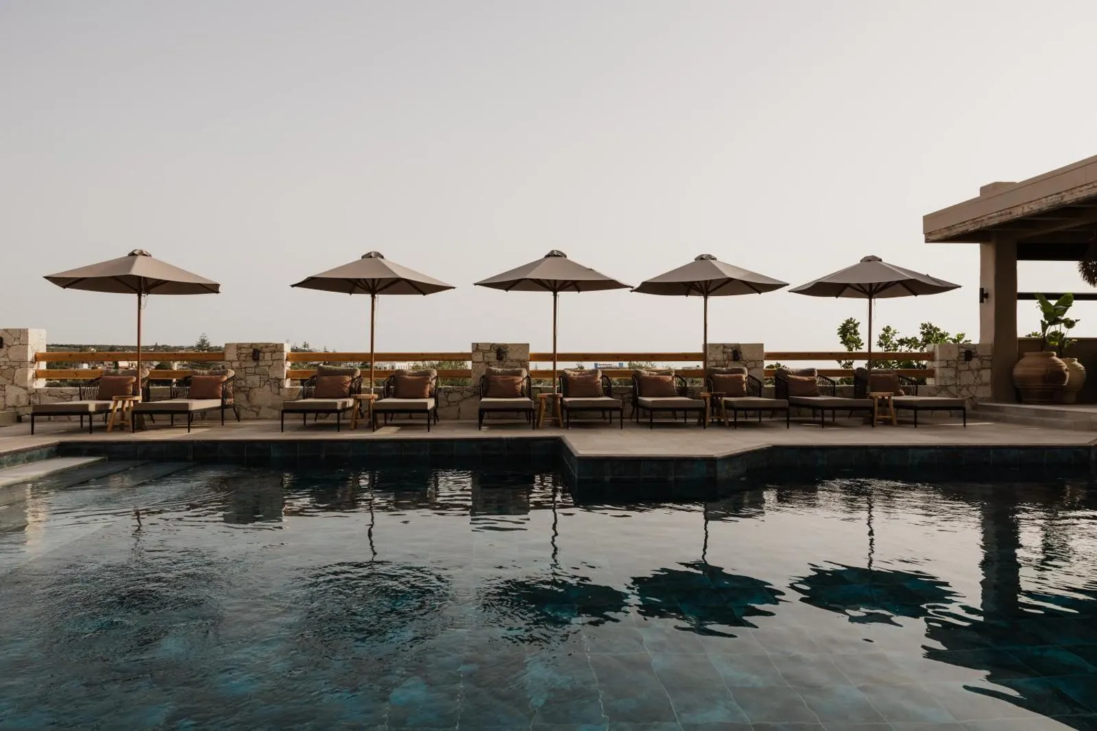 Pool with umbrellas and loungers at dusk