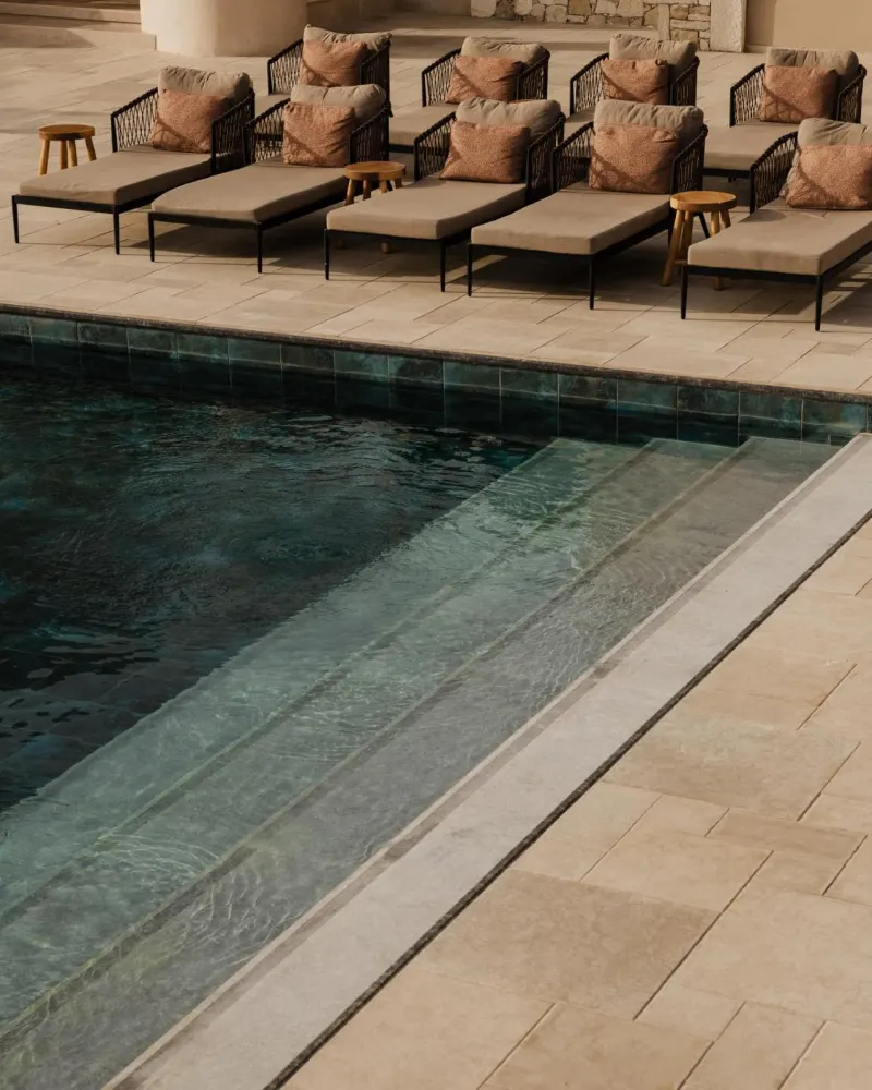 Infinity pool edge with lounge chairs and pillows