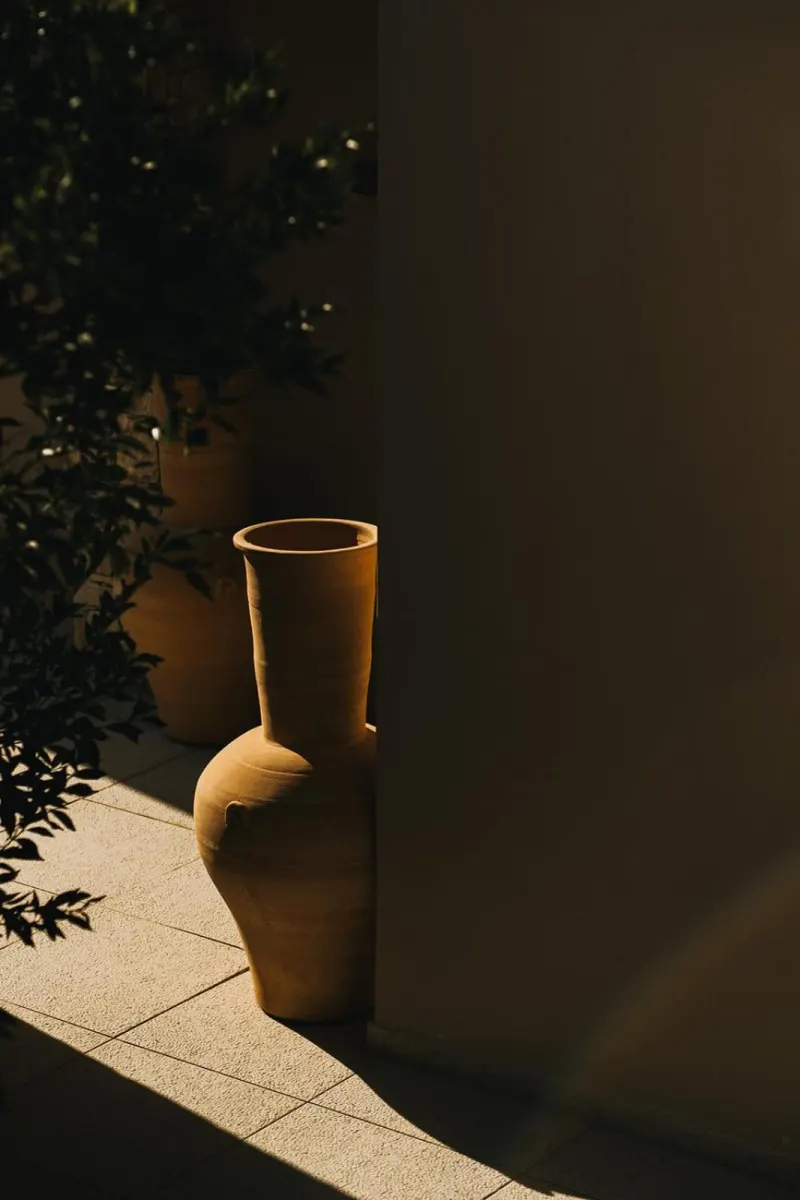 Terracotta vase in shadowed courtyard corner