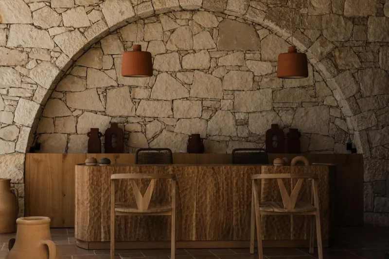 Stone archway bar with pendant lamps and pottery