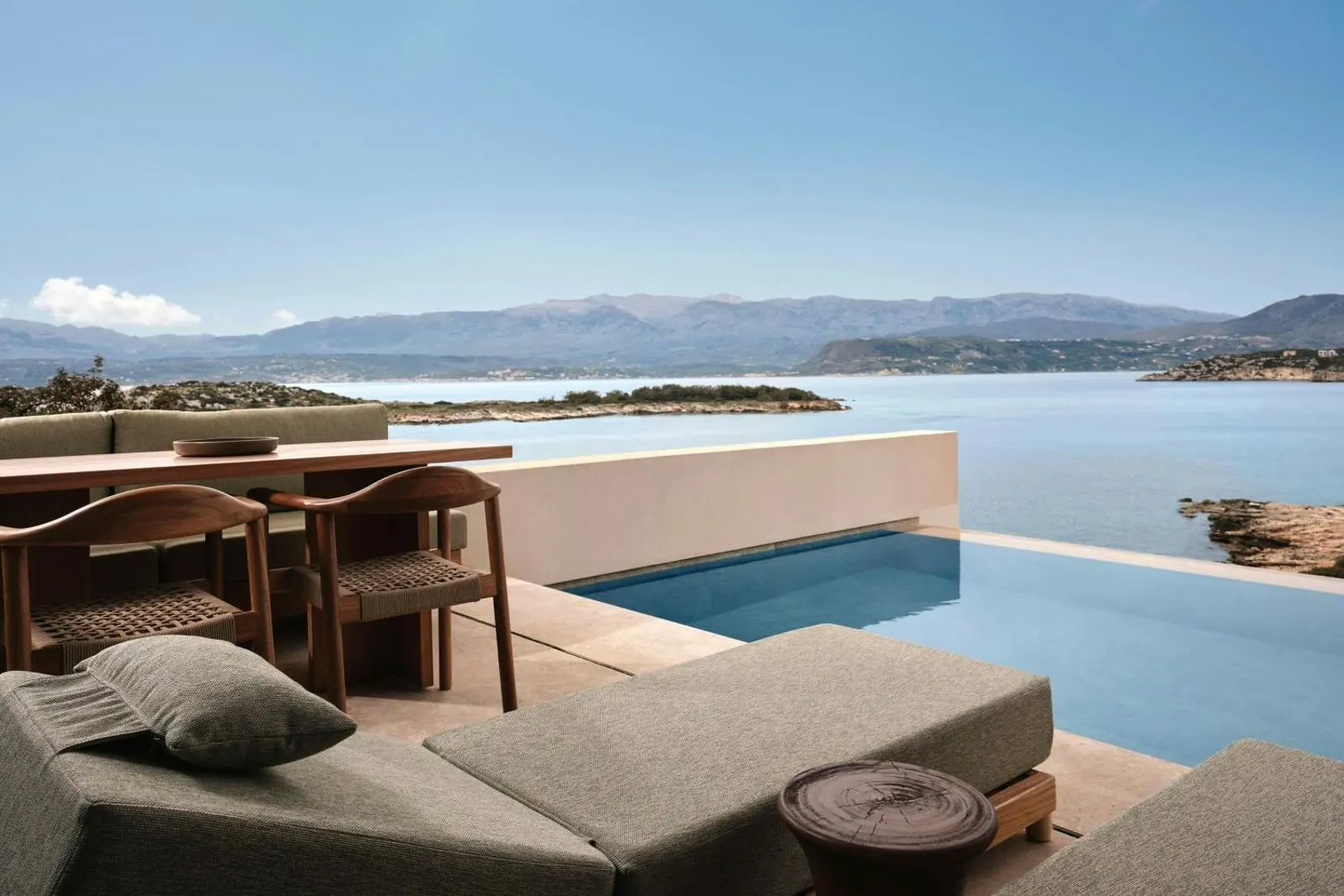 Infinity pool terrace with sun loungers overlooking bay