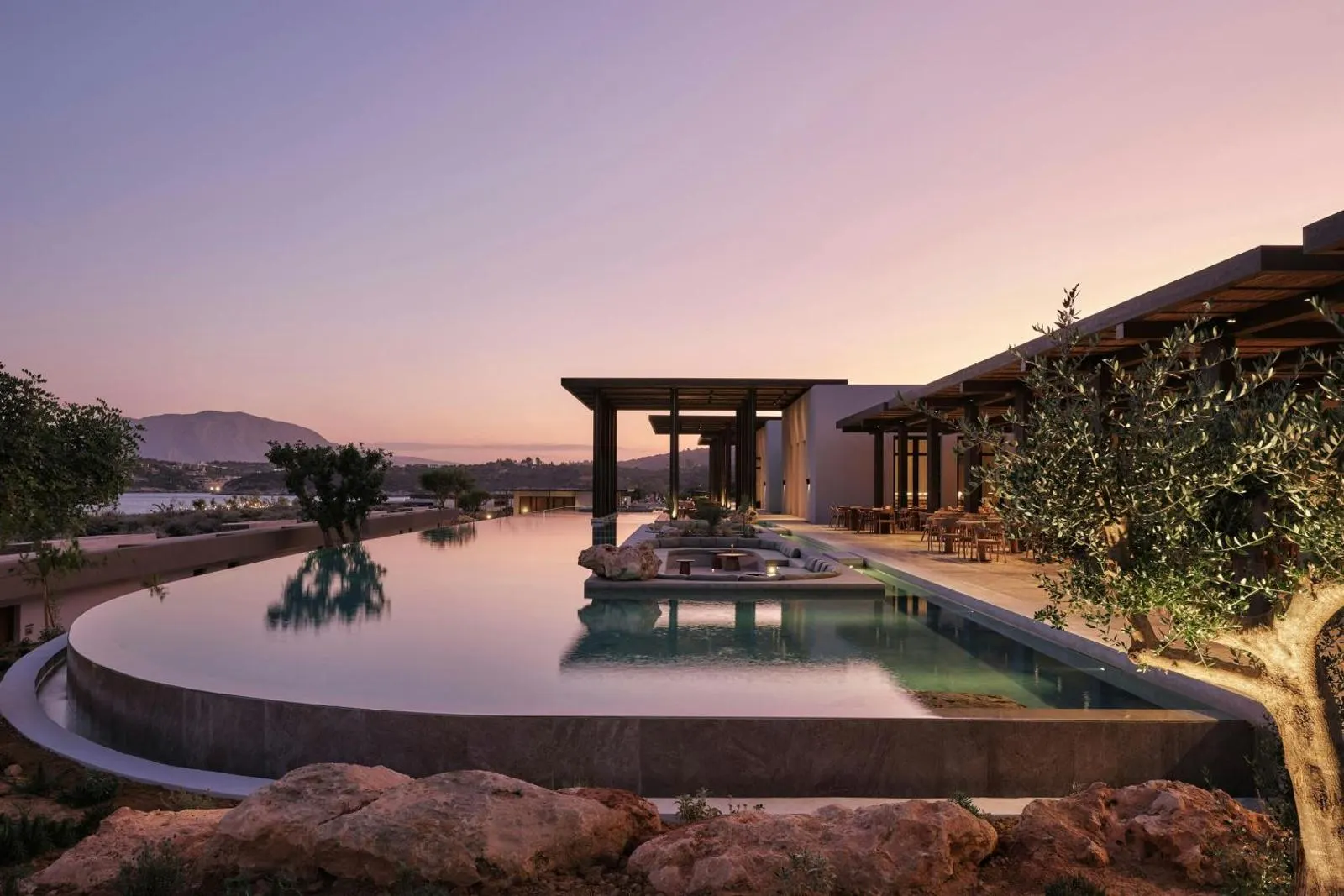 Sunset view of pool and pergola with mountain backdrop