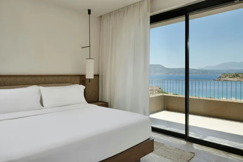 Bedroom with large window overlooking coastline